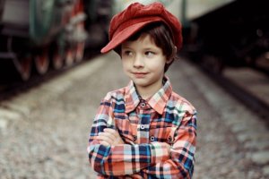 young child wearing a red hat and flannel shirt