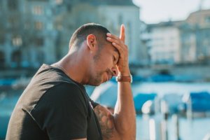 a man who looks distressed with his hand on his forehead