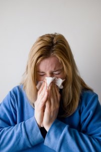 woman blowing her nose with a tissue